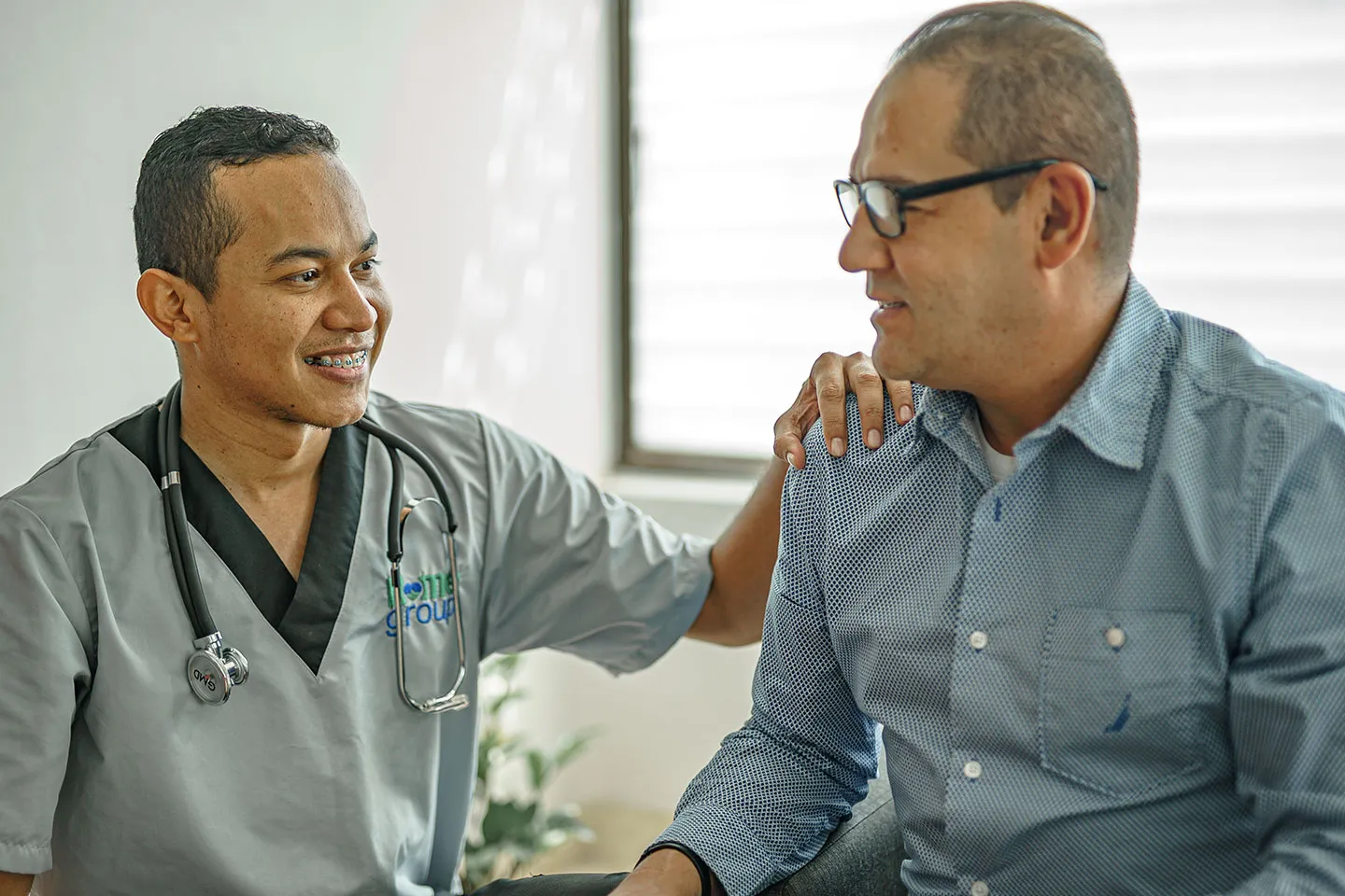 Médico de Home Group conversando con un paciente